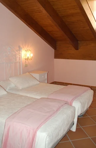 Dormitorio de Casa Rojanda con camas individuales y techo de madera
